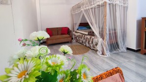 A bedroom with a canopy bed, a sofa, and a decorative plant arrangement. - Matota Family Villa (Matara)