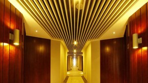 A long, narrow hallway with wooden walls and a patterned ceiling. - Sanya Serenity Coast Marina Hotel (Sanya)