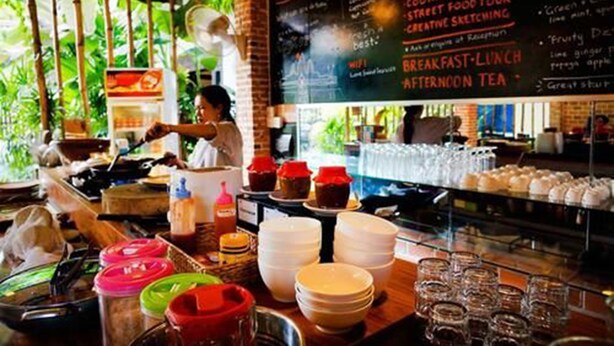 A restaurant interior with a chalkboard menu, cooking classes, and a variety of dishes displayed. - Uncle Sam Villa (Siem Reap)