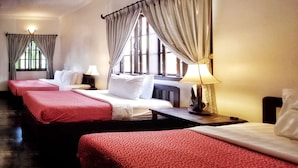 A hotel room with three beds, each with red and white bedding, a large window with curtains, and a lamp on the nightstand. - Uncle Sam Villa (Siem Reap)