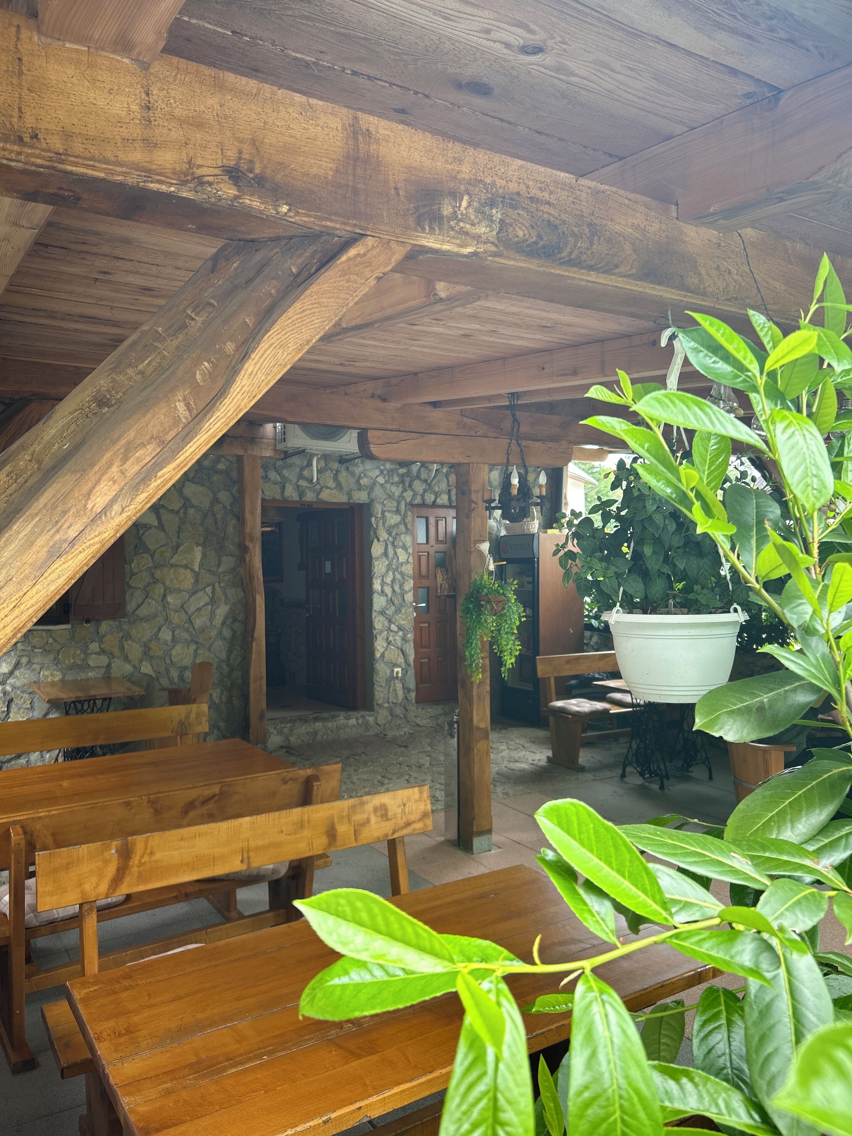 A rustic wooden dining area with benches and a stone wall.