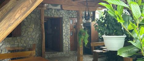 A rustic wooden dining area with benches and a stone wall.