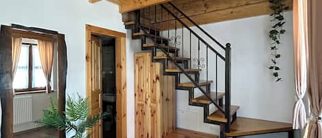Interior de madera con una escalera, paredes de madera y un espejo grande.