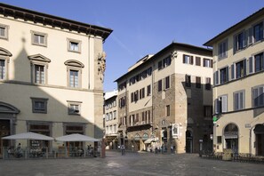 Une place historique à l’architecture traditionnelle, dotée d’une terrasse et offrant une vue sur un ciel dégagé.