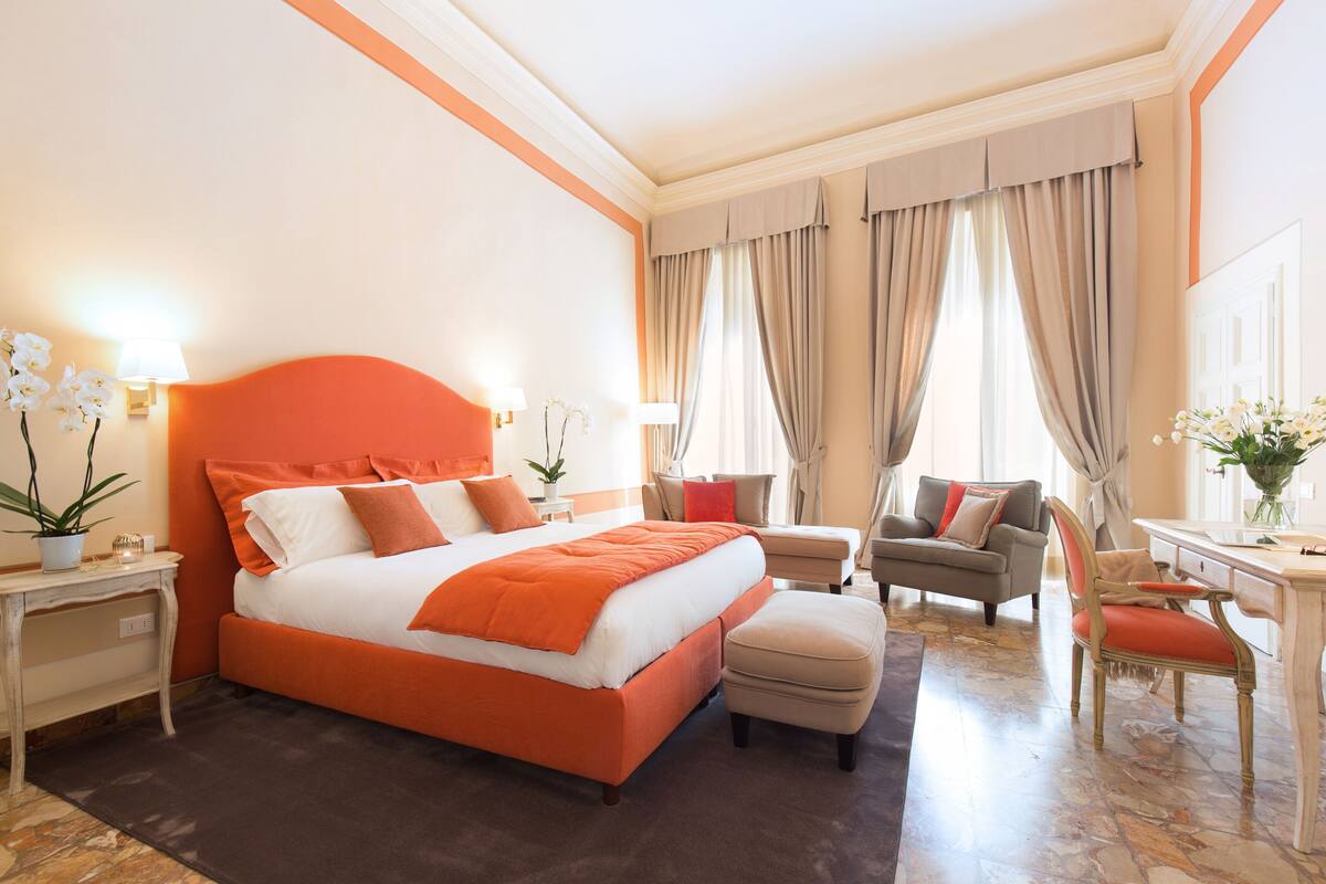 Een hotelkamer met een groot bed, een bureau, een stoel en een bank.