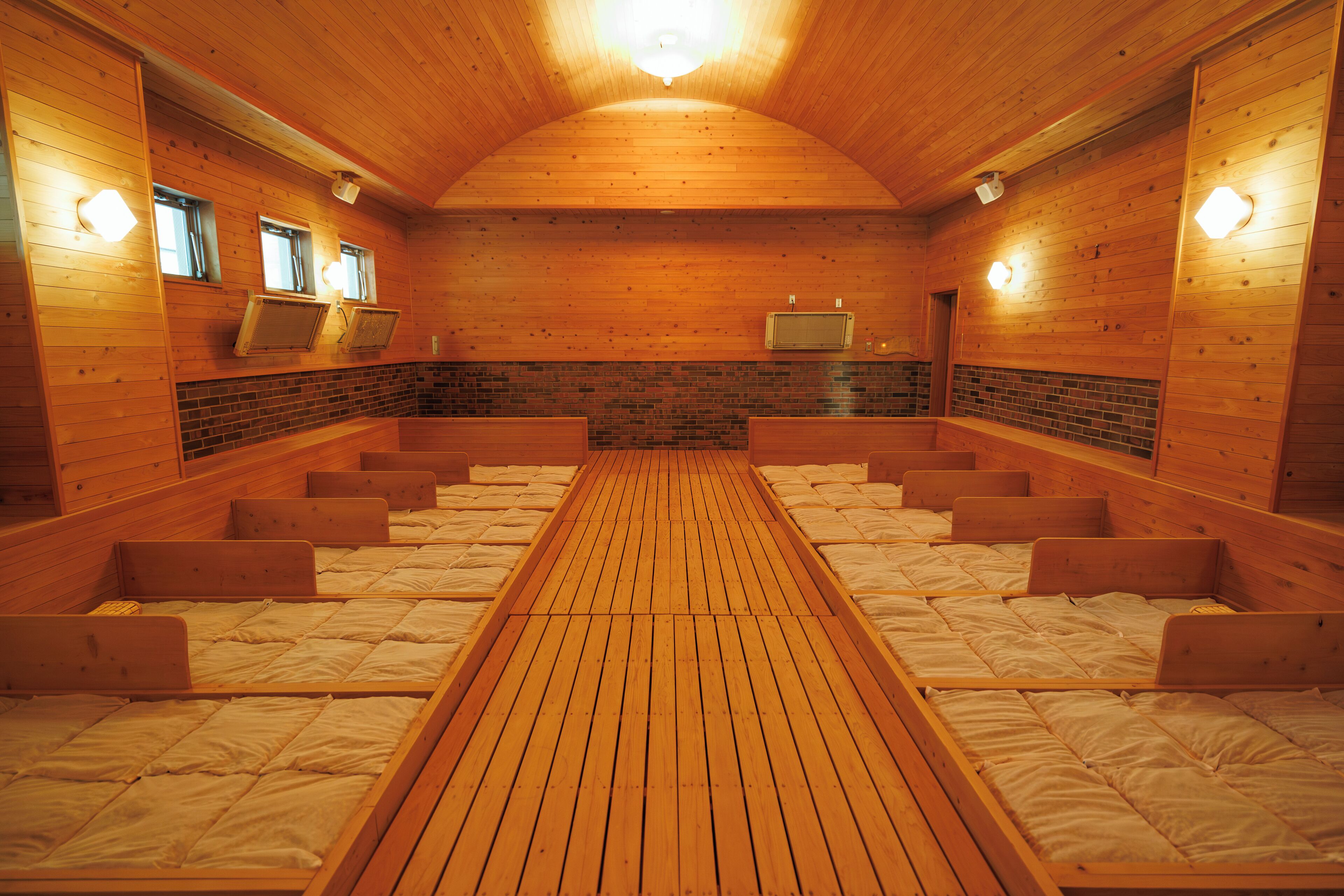 A sauna room with wooden benches and a central walkway.