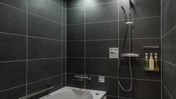 A modern bathroom with a bathtub, a shower, and a toilet.