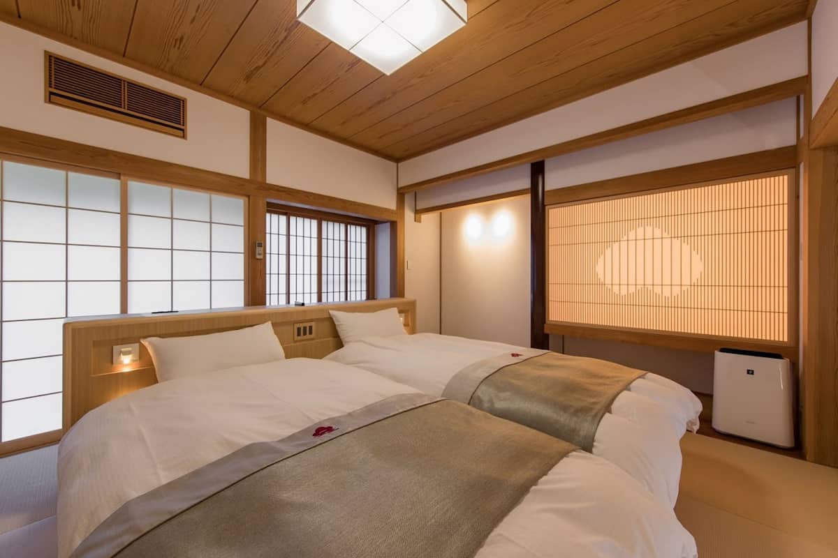 Une chambre de style japonais traditionnel, avec un sol recouvert de tatamis, un plafond en bois et des portes coulissantes de type shoji.
