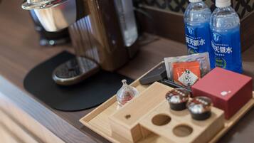Una bandeja de madera con bolsitas de té, un vaso y una caja roja sobre una mesa.