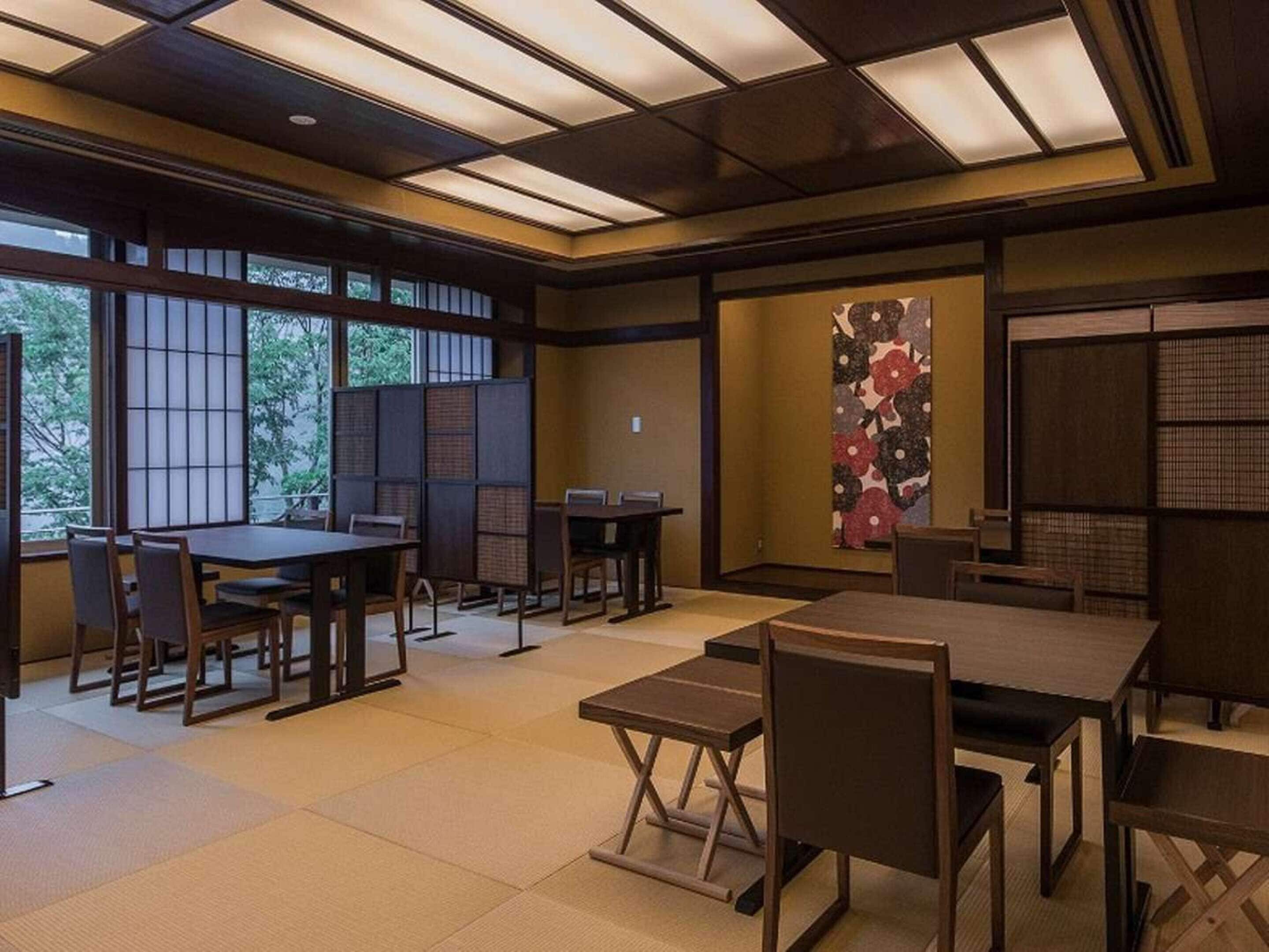 A traditional Japanese-style room with tatami flooring, low tables, and sliding doors.
