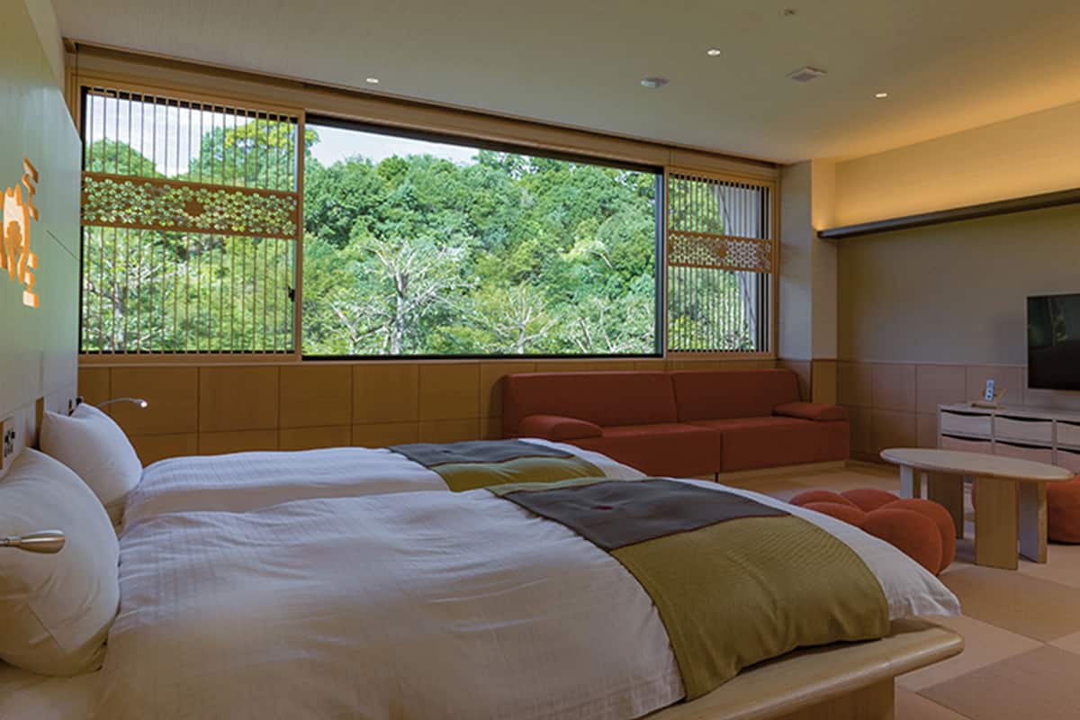 Une chambre moderne avec un grand lit, un coin salon et un téléviseur.