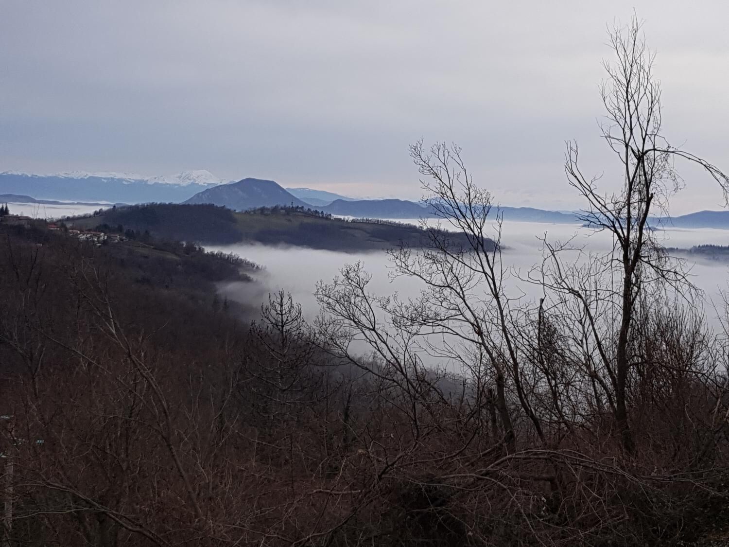 A mountainous landscape with a valley and a mountain in the distance.