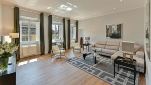 A modern living room with a sofa, chairs, a coffee table, and a fireplace. - Santa Croce Deluxe (Florence)