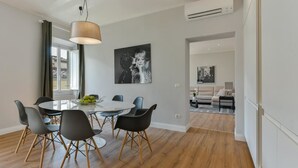A modern dining area with a round table, black chairs, and a hanging light fixture. - Santa Croce Deluxe (Florence)