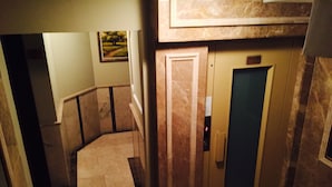 A hallway with a marble floor, a door with a keypad, and a framed picture on the wall. - Kadıköy Park Suites (Istanbul)