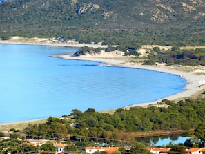 Uma área costeira com uma praia, uma vila pequena e um lago.