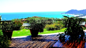 A wooden deck with potted plants and a bench overlooking a coastal view. - Comino Alto Agriturismo e  Appartamenti (Siniscola)