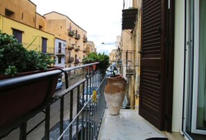A narrow balcony with a metal railing, a large terracotta pot, and a door to a building. - B&B Rabaté (Agrigento)