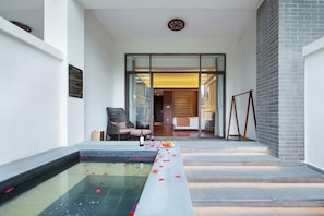 A spa area with a pool, a lounge chair, and a staircase leading to a room. - Lanshanyuan LN Dongfang Hotspring Resort (Shaoguan)