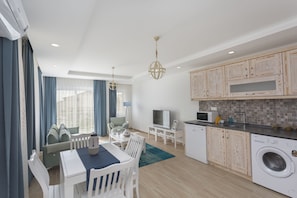 Una cocina moderna con armarios de madera, lavadora y comedor con mesa y sillas.