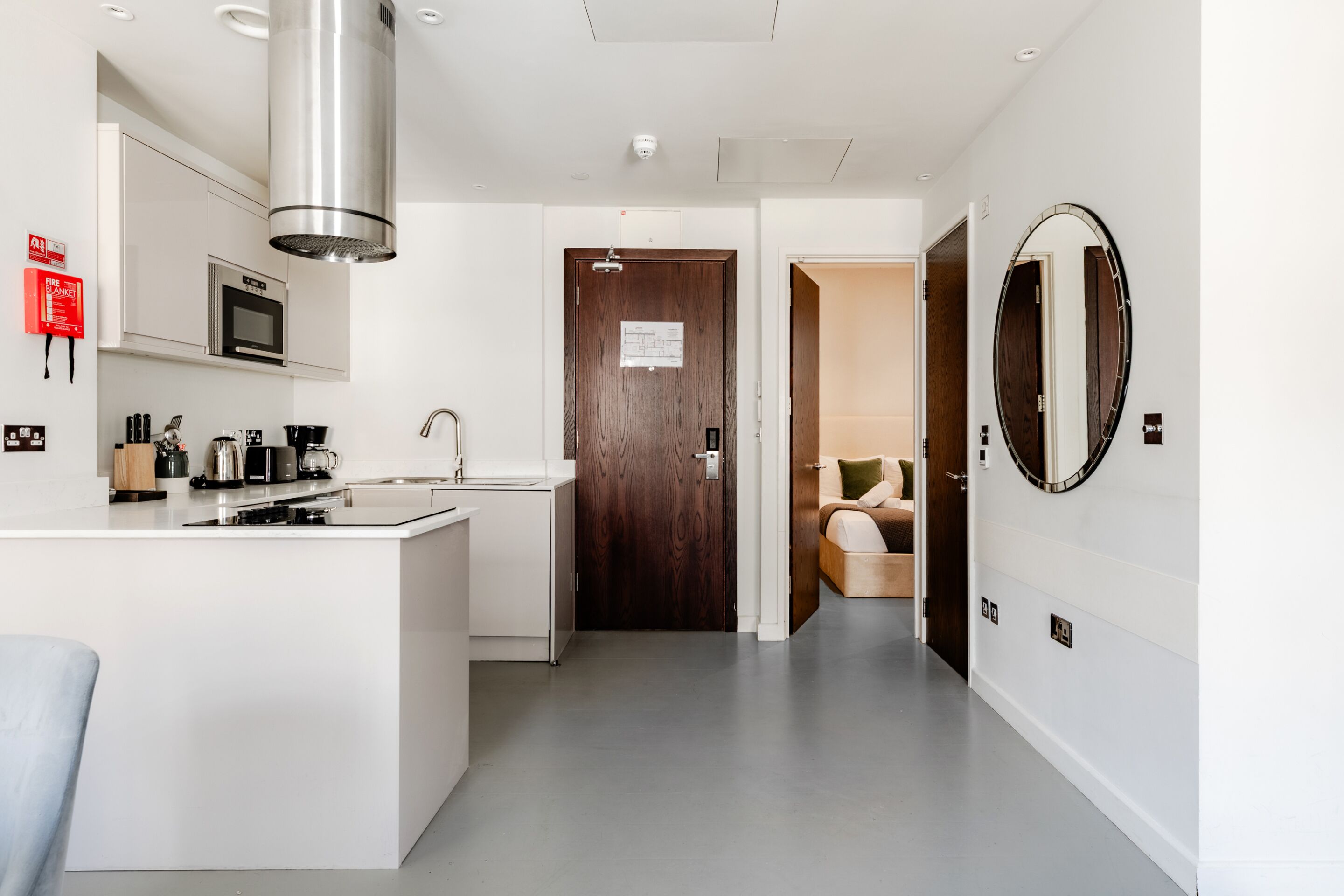 A modern kitchen with a central island, built-in microwave, and stainless steel range hood.