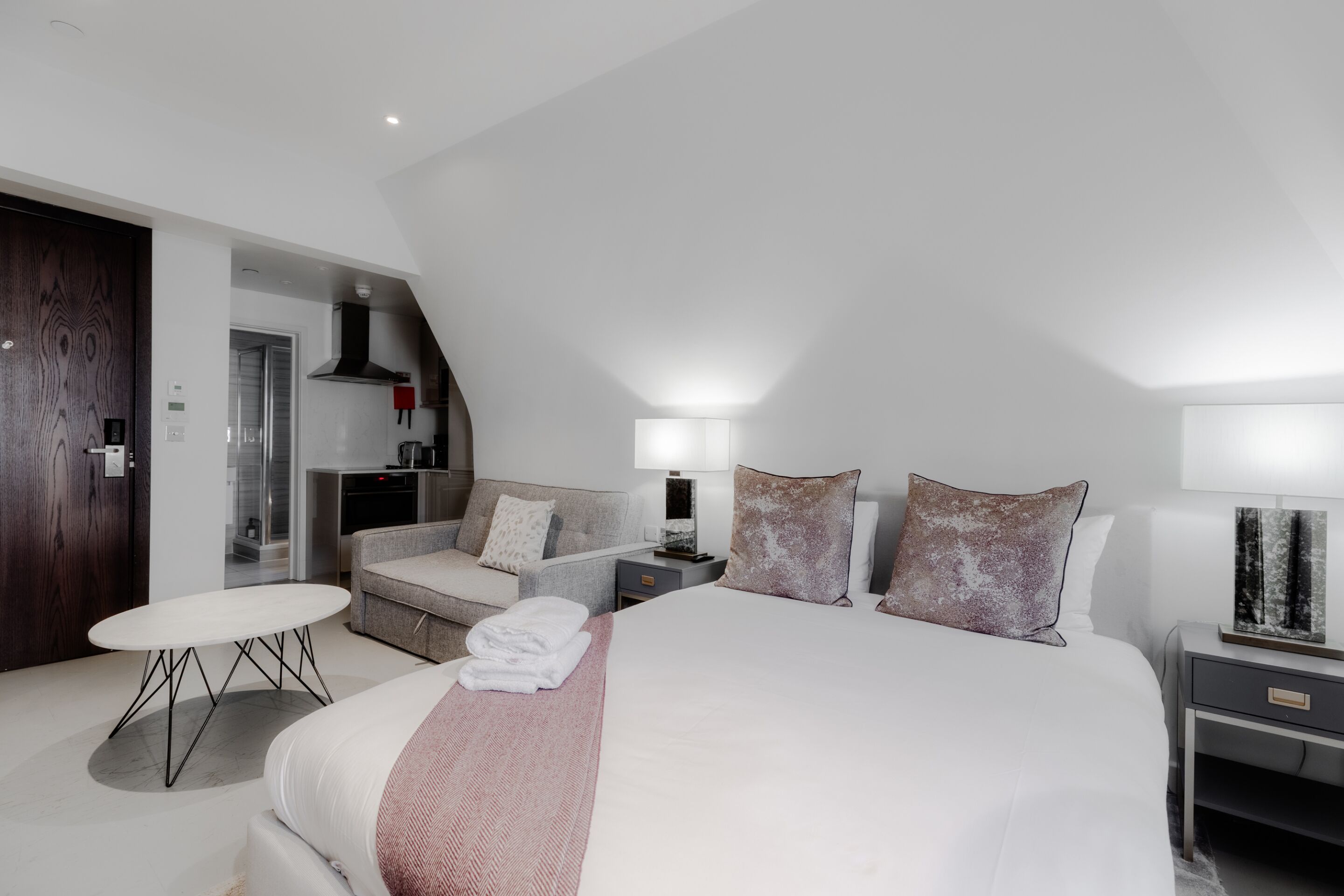 Ein modernes Hotelzimmer mit einem großen Bett, einer Couch, einem kleinen Tisch und einem Schreibtisch.