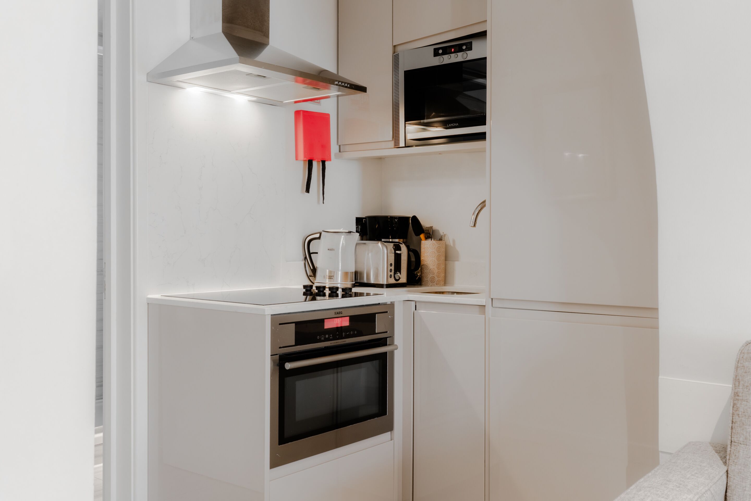 A compact kitchen with a built-in oven, a microwave, and a coffee maker.