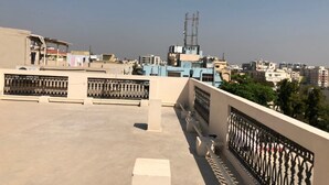 Une terrasse sur le toit offrant une vue dégagée sur le paysage urbain, avec des bâtiments et une tour de communication.