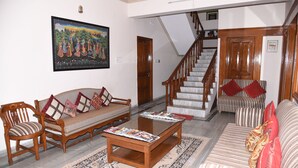 Un salon comprenant un canapé, un fauteuil, une table basse et un escalier.