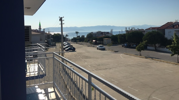 En balkong med utsikt över en parkeringsplats, med fri sikt över havet och de avlägsna bergen.