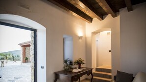 Una sala de estar acogedora, con pared de piedra, techo de madera y vistas al exterior.