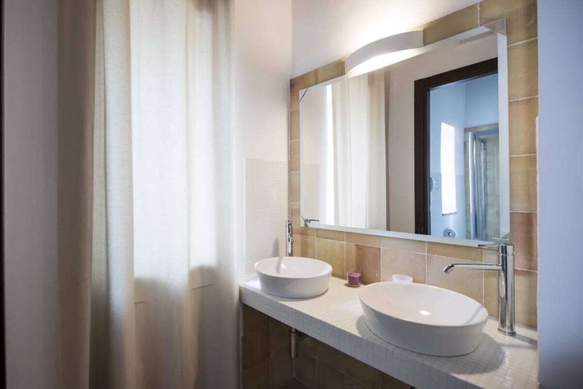 A bathroom with two sinks, a large mirror, and a towel rack.