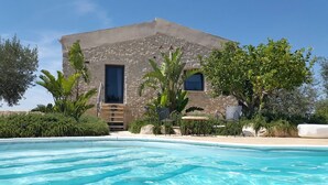 Una piscina con un edificio de piedra al fondo.