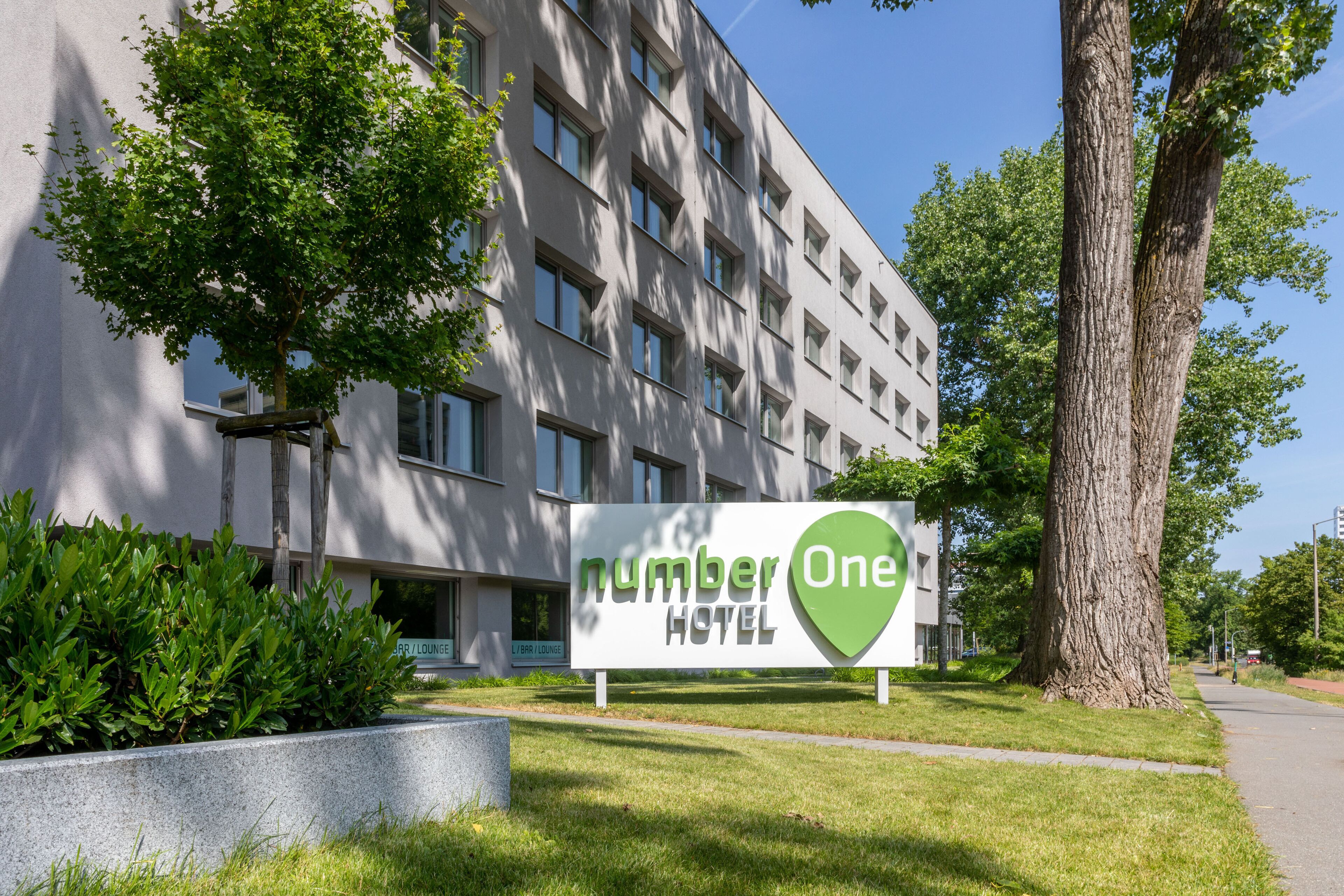 Ein Hotelschild vor einem modernen Gebäude im Hintergrund.