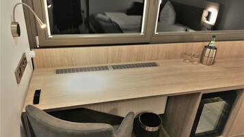 Una cocina americana moderna con encimera de madera, estufa integrada, pileta y ventana con persianas.