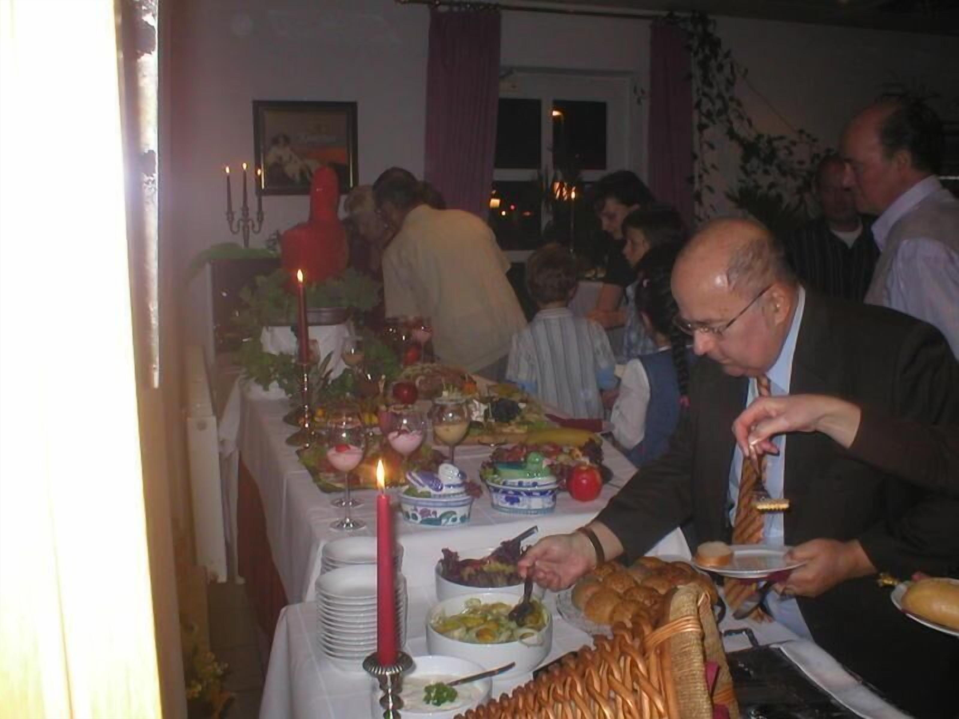 Un comedor con una mesa dispuesta para una comida, que incluye varios platos y una vela encendida.