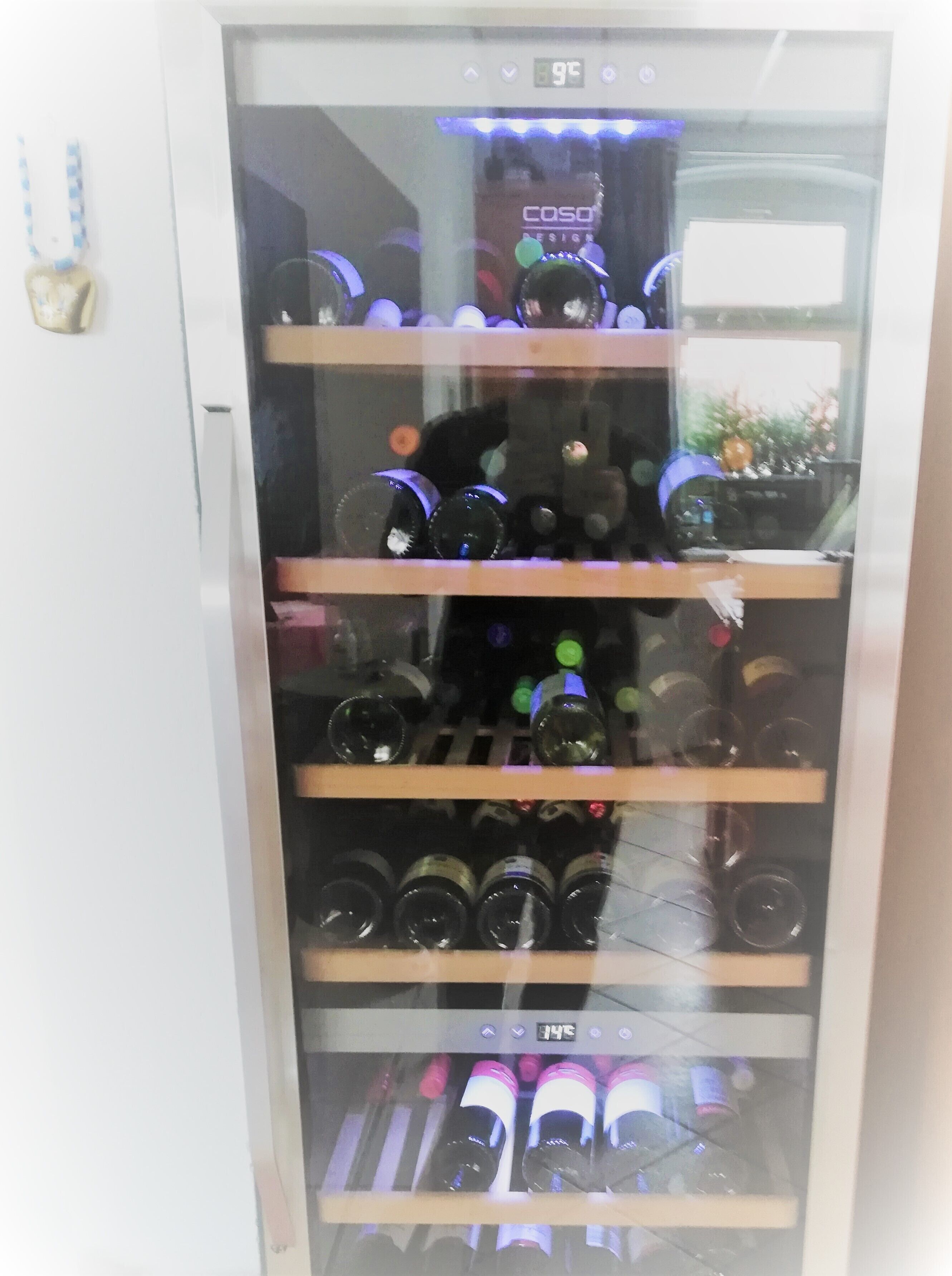A refrigerated display case with multiple shelves of bottled beverages.