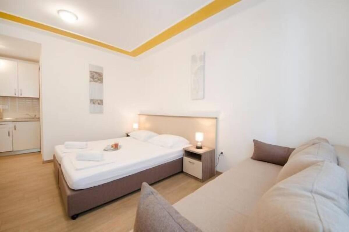 Ein modernes Schlafzimmer mit Bett, Nachttischen und einer Couch.