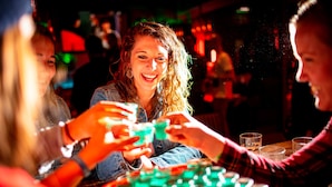 A group of people playing a game at a bar.