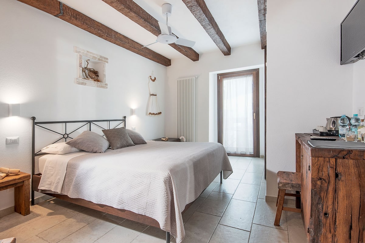 Ein Schlafzimmer mit Bett, Nachttisch und einem Holztisch mit Stuhl.