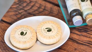 Two round soaps on a white plate with a wooden table background.