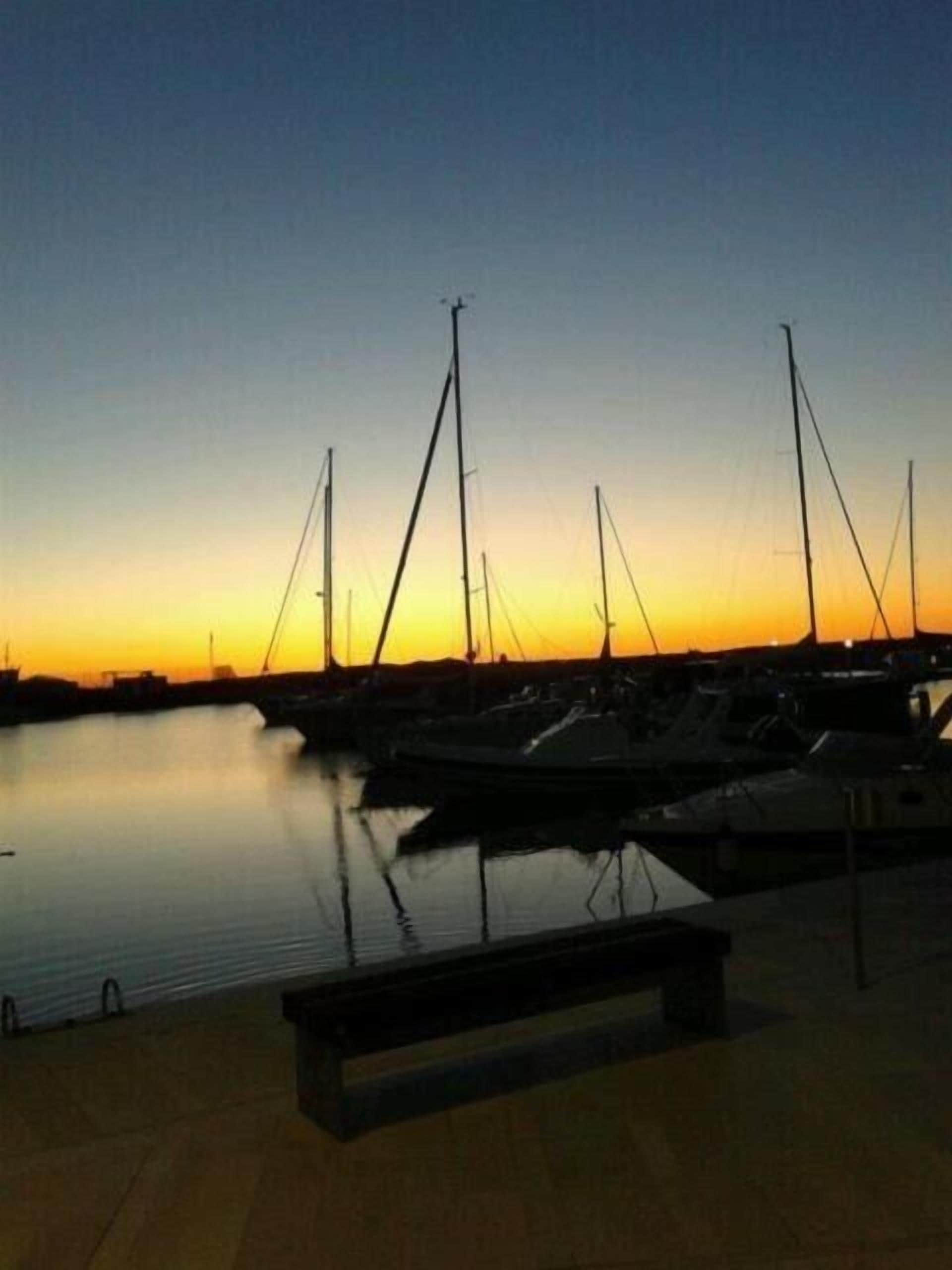 A marina at sunset with boats docked.