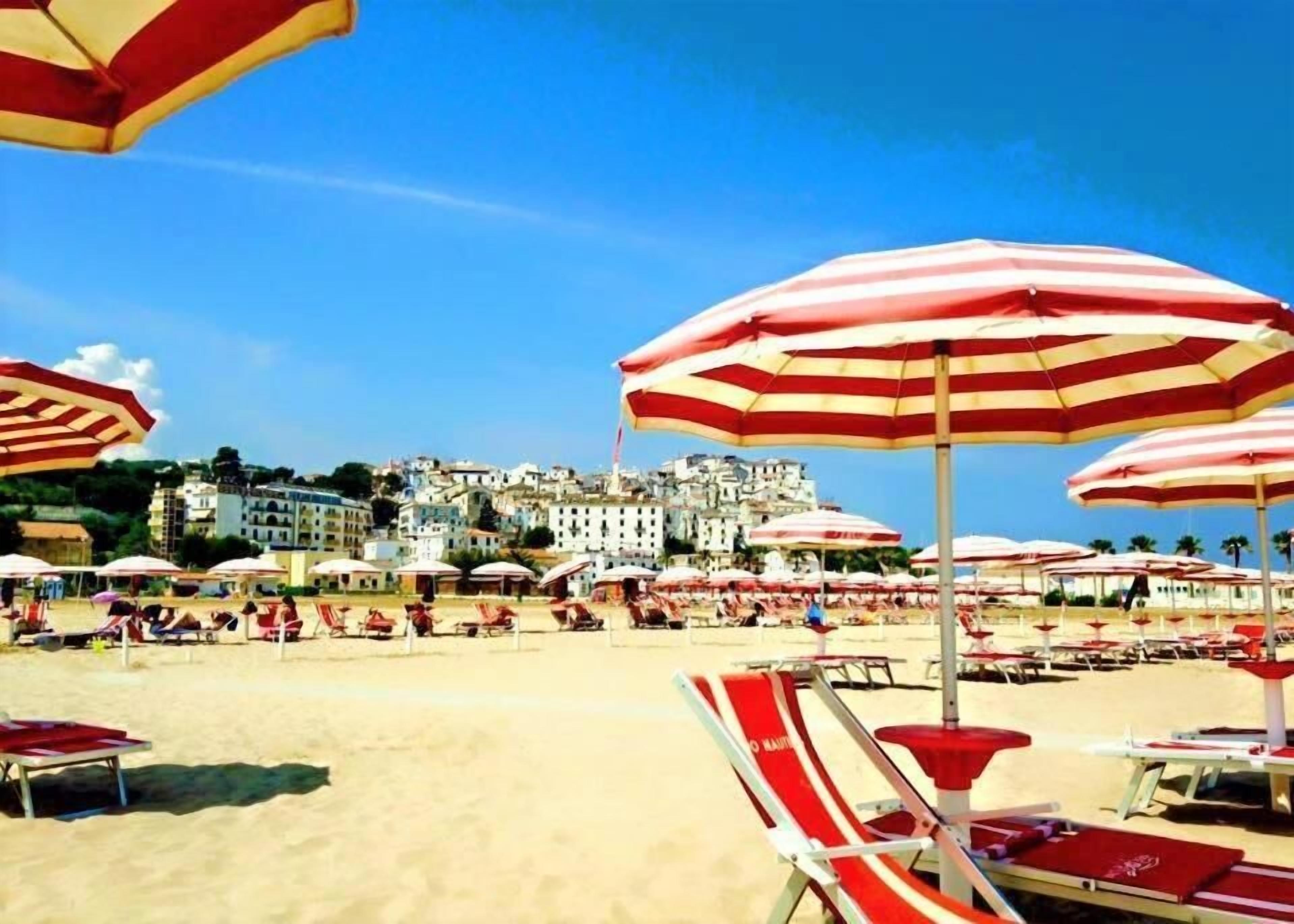 Privéstrand vlakbij, wit zand, ligstoelen aan het strand, parasols