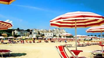 Privéstrand vlakbij, wit zand, ligstoelen aan het strand, parasols