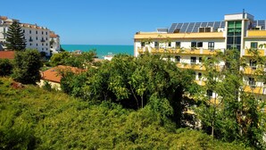 Un hôtel à plusieurs étages, doté de panneaux solaires sur le toit et offrant une vue sur la mer.