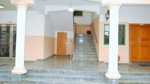 A staircase with marble steps leading to a wooden door at the top. - Daneto Hotel (Port Harcourt)