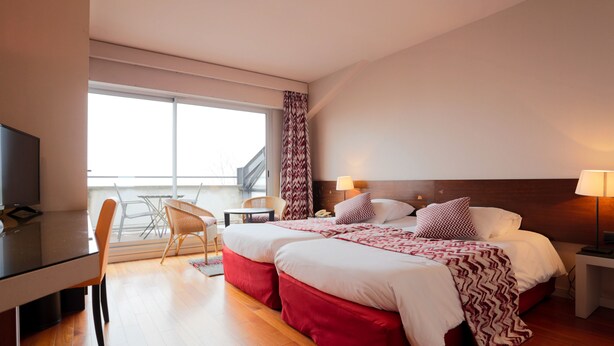 A hotel room with a bed, bedside tables, a desk, and a chair. - Hôtel l'Ermitage (Espaly-Saint-Marcel)