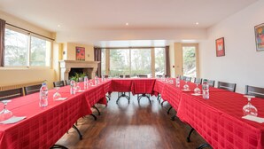 A conference room with a long table covered in red tablecloths, equipped with water bottles and wine glasses. - Hôtel l'Ermitage (Espaly-Saint-Marcel)