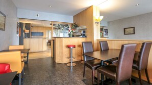 A modern restaurant with a central bar area, wooden paneling, and a mix of seating options including bar stools and tables. - Hôtel l'Ermitage (Espaly-Saint-Marcel)