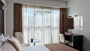 أغطية فراش متميزة وخزنة داخل الغرفة ومكتب وستائر تعتيم
